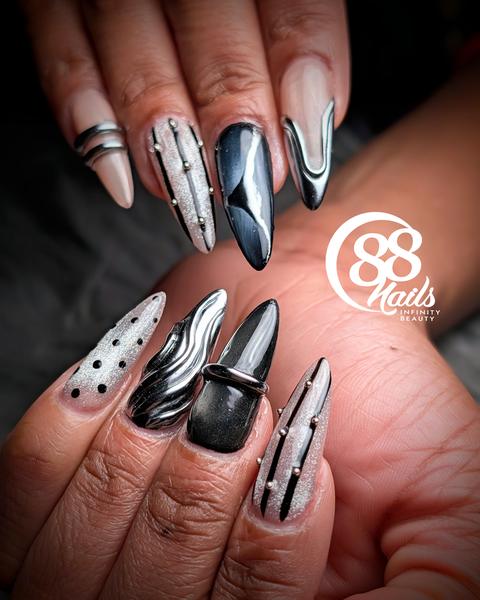Black and white abstract nail art with chrome stripes and polka dots on almond nails at 88 Nails Lewisville